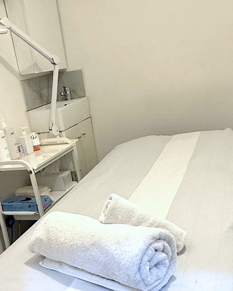 Rolled towels on a prepared treatment couch at Pure Essentials London